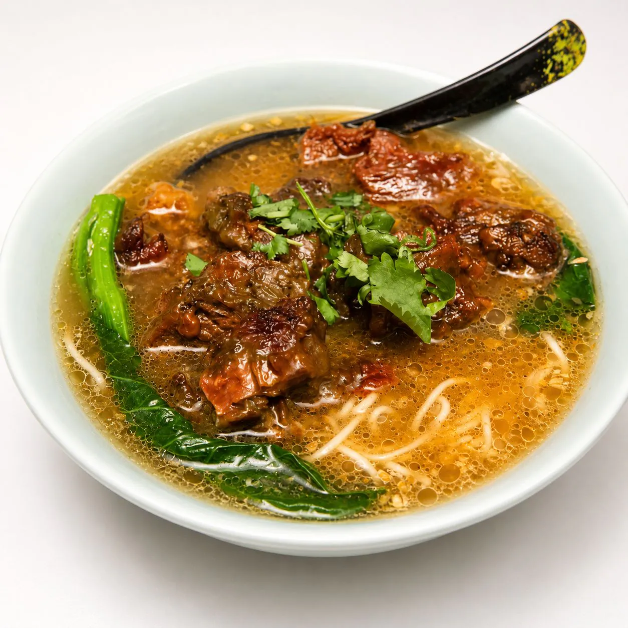 Braised beef brisket soup noodle with herbs and greens
