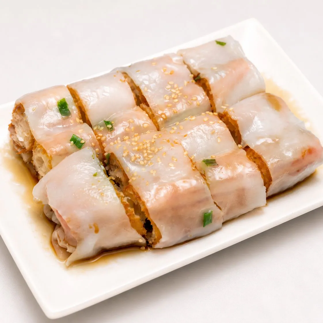 Fried dough rice noodle roll on white rectangular plate
