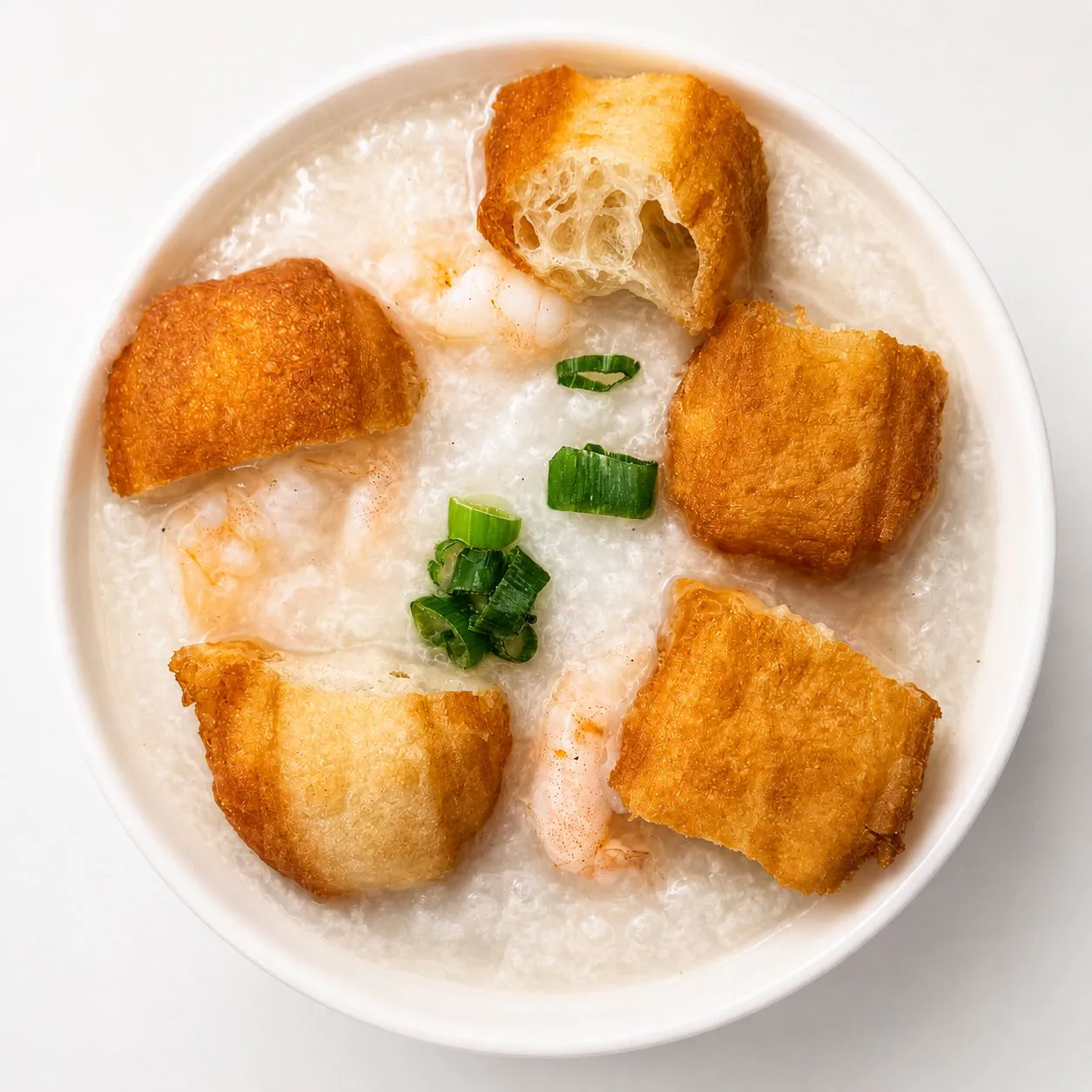 Shrimp congee with fried croutons and chopped green onions